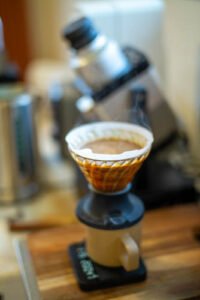 Hario V60 Switch dripper with a paper filter, brewing coffee into a cup on scales