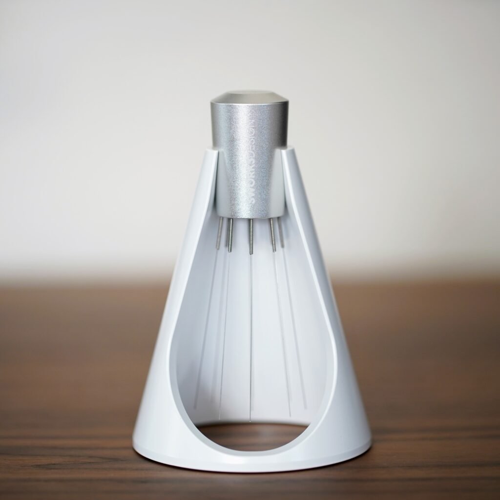 Sworksdesign WDT tool with fine needles, standing in its white cone-shaped stand